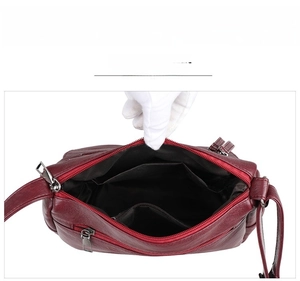 Detail view of the multi-layer interior compartments and zipper pockets of a leather bag