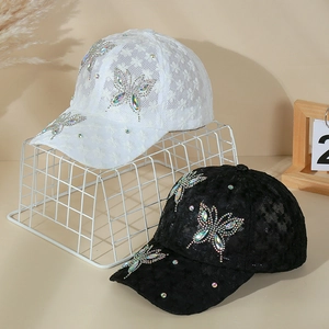 Detail view of lace baseball caps with rhinestone butterfly in black and white colors