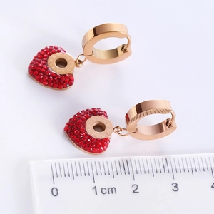 Luxurious stainless steel heart earrings with red rhinestones and ruler for size scale