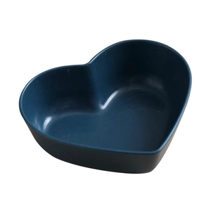 Dark blue heart-shaped seasoning dish made of wheat straw fiber on white background