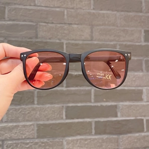 Detail of round foldable kids sunglasses with UV400 protection and matte black frames