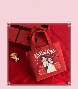 Detail of red wedding canvas tote bag with cartoon bride and groom and festive symbols