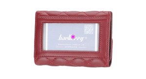 Close-up of burgundy leather card holder with diamond quilted pattern and clear ID window