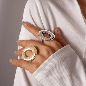 Minimalist chunky hollow metal oval rings in gold and silver finish on model's hand