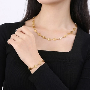 Golden clover necklace and bracelet set featuring continuous hollowed lucky clover pattern