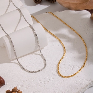 Detail shot of textured gold and silver link chains with elegant autumn decor