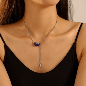 Lucky bean pendant necklace with silver chain and blue bean charm shown on a model
