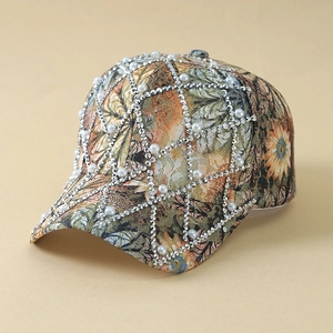 Lace floral baseball cap with rhinestone mesh and pearl accents on a beige background
