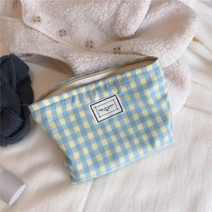Detail of blue and yellow plaid cotton pouch with Time to Party patch and metal zipper
