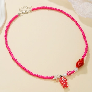 Dettaglio collana di perle rosa con ciondoli a forma di stella marina e pesce estivo