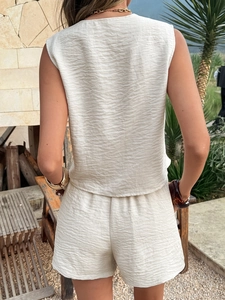 Back view of beige pleated sleeveless top and shorts set for a summer resort look
