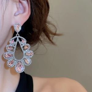 Detailed view of silver drop earrings with pink teardrop crystal and sparkling diamonds