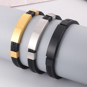 Macro detail of men's braided leather bracelets in gold, silver and black finishes