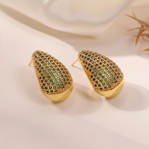 Detailed view of 18K gold teardrop earrings with green pavé cubic zirconia accents