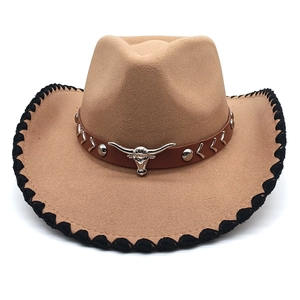 Detail of western cowboy hat with silver bull head emblem and black braided edge