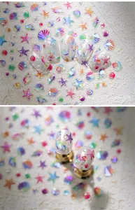 Macro detail of 3D iridescent shell and starfish ocean theme nail art stickers