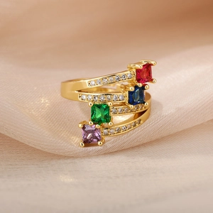 Close-up of multi-layer gold ring with colorful square zircons on chiffon fabric