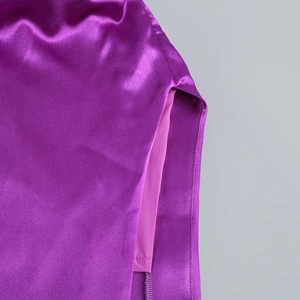 Détail de la fente latérale haute et du tissu satiné violet d'une robe de soirée