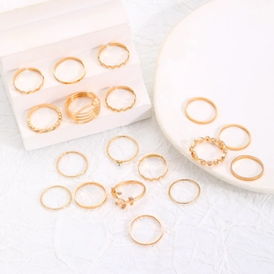 Detail view of 16-piece gold ring set featuring rhinestones and leaf designs on white stands