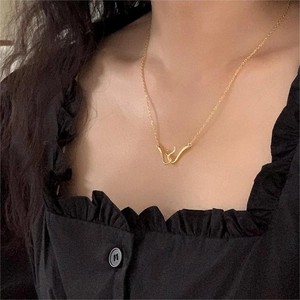 Close-up of minimalist gold curved pendant necklace worn on a female neck model