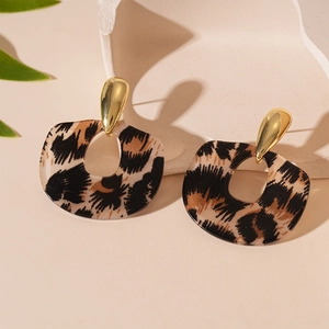 Gros plan sur les boucles d'oreilles léopard en acrylique avec clous dorés