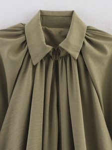 Detailed view of the olive green jacket collar with pleated fabric and metallic zipper