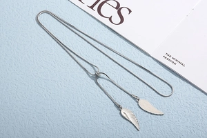 Detail of silver snake chain necklace with elegant wing pendants and sliding ball clasp
