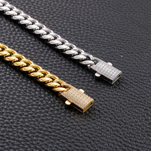 Detailed close-up of gold and silver Cuban link chains with iced-out rhinestone clasps