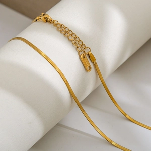 Detail of golden snake bone chain necklace with lobster clasp and S.Steel hallmark