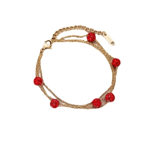 Multi-layer gold stainless steel bracelet with six red sparkling crystal beads on white background