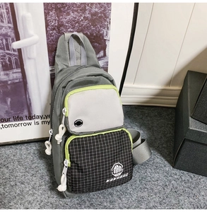 Detail of water-resistant gray crossbody bag with checkered pattern and green trim