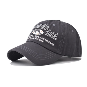 Detail of grey washed cotton baseball cap with white Dolphin Hotel 3D embroidery