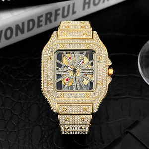 Close-up of luxury gold iced-out square watch with skeleton dial on black leather background