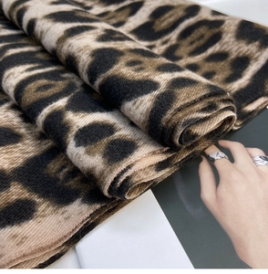 Close-up of thick leopard print scarf showing soft cashmere-like texture and fringed edges