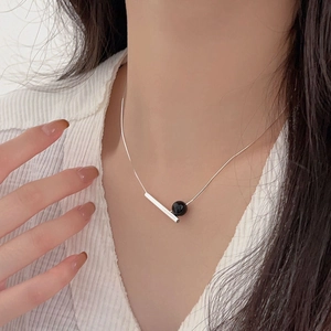 Macro view of minimalist 925 silver necklace featuring a black onyx square tube pendant