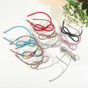Detailed view of colorful rhinestone bow headbands and hair clips on a white background