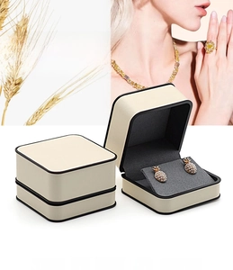 Macro view of cream PU leather jewelry box featuring black trim and black foam insert