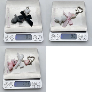 Weight measurement of cute flocked cat charms with heart pearls weighing around 10 grams