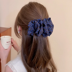 Détail d'une pince à cheveux en tissu imprimé léopard sur une coiffure attachée