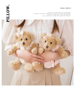 Close-up of plush teddy bears with lace dresses and bows in soft aesthetic setting