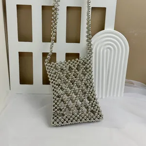 Macro detail of handmade silver metallic beaded crossbody bag with woven pearl texture