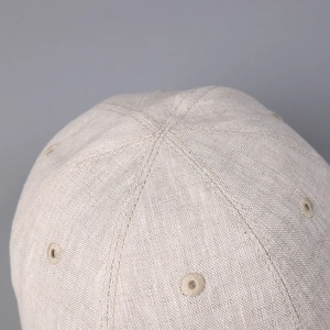 Detailed macro view of beige linen baseball cap fabric texture and cross stitching