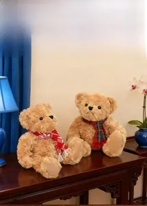 Detail of two plush teddy bears with colorful scarves in a cozy home setting