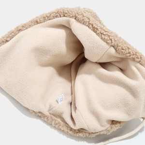 Dettaglio della fodera in pile beige e bordo in lana d'agnello di un cappello invernale