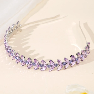 Detail of purple rhinestone headband with leaf motifs and vine patterns on metal