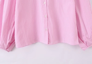 Dettaglio ravvicinato del tessuto della camicia a righe rosa e bianche con bottoni