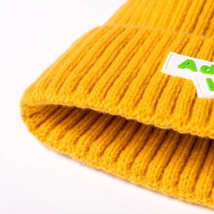 Bright yellow ribbed knit beanie for women and men featuring a green letter Ad patch