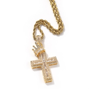 Detail of gold iced out cross pendant with crown design on a twisted rope chain necklace