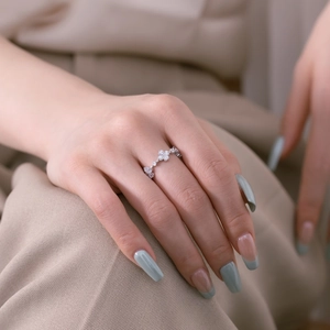 Detail of S925 sterling silver flower ring with zircon stones worn on finger