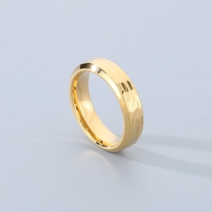 Detailed close-up of a gold-toned hammered texture ring with a smooth polished inner band